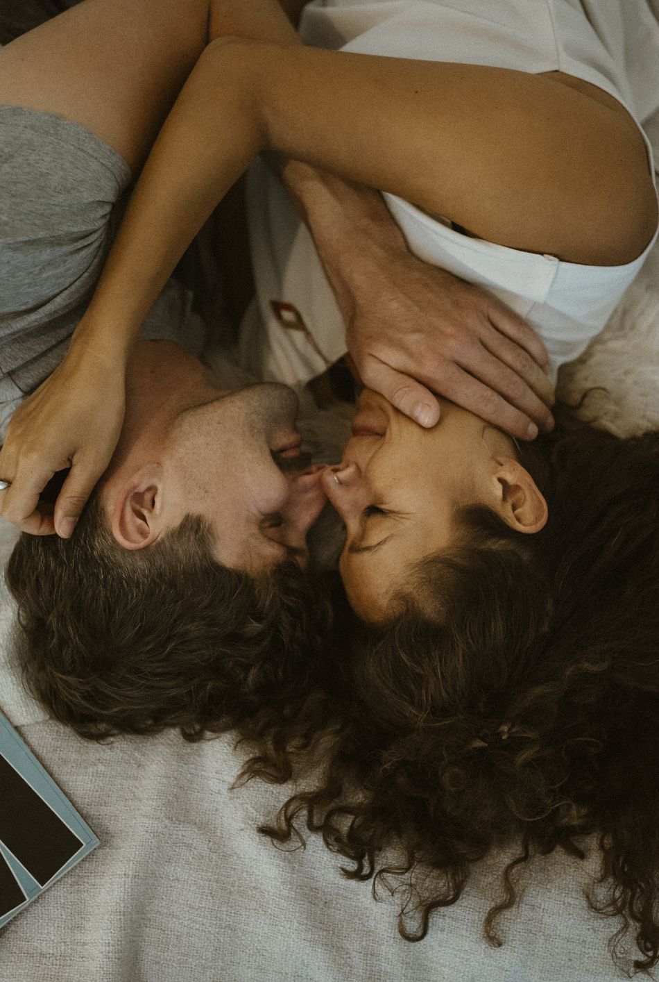 directly above view of romantic couple rubbing noses while lying on bed at home