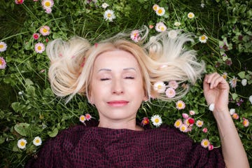 mujer tumbada sobre hierba con flores