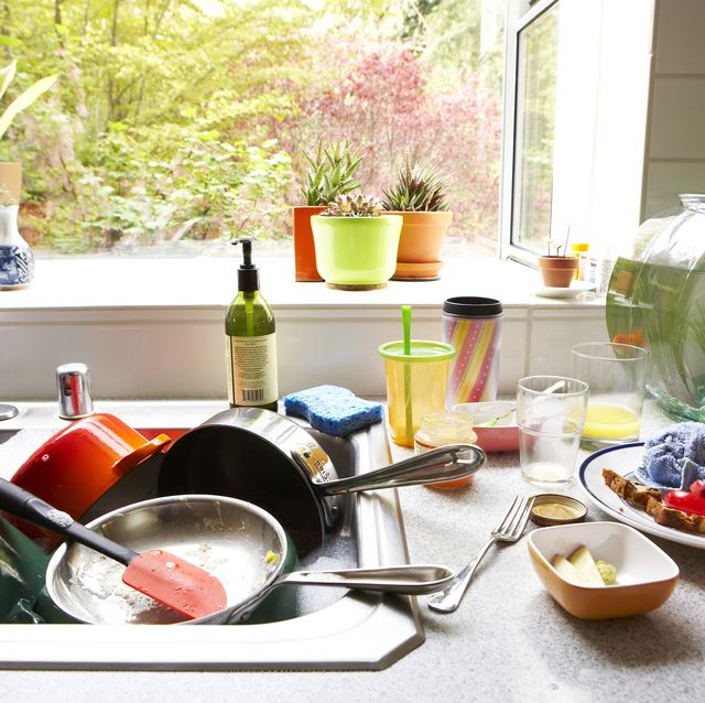 dirty dishes piled in kitchen sink, close up