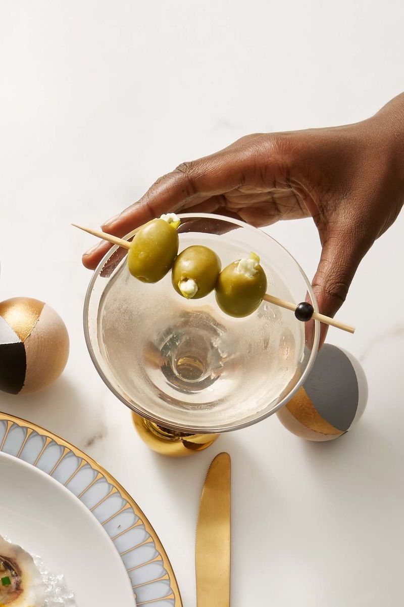 martini with stuffed olives on a stick