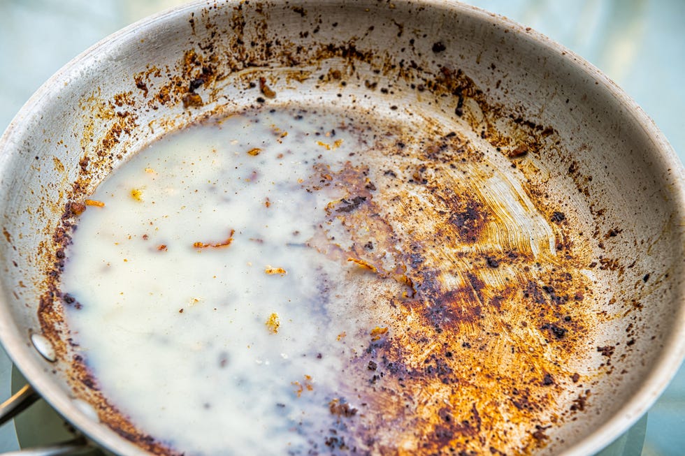 dirty oily pan with cold solid grease saturated fat from bacon after frying macro closeup as unhealthy leftover cleaning job