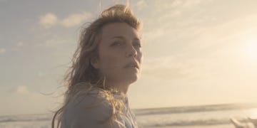 person stands on the beach during sunset