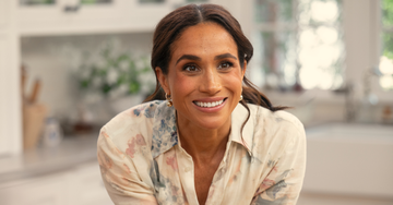 meghan markle wearing a floral shirt in a kitchen setting