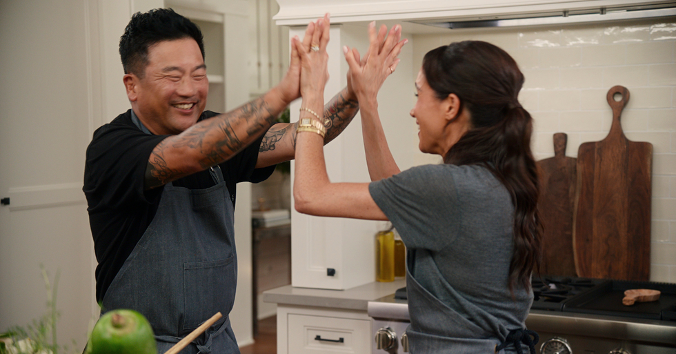 two individuals engaged in a playful cooking interaction in a kitchen