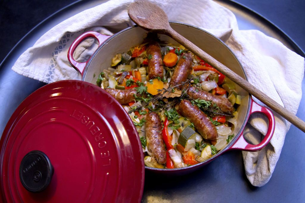 le creuset cast iron casserole dish with sausages