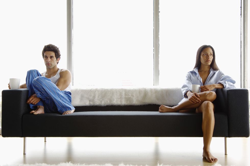 una hombre y una mujer sentados lo más alejados posible en un sofa