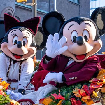 mickey and minnie mouse sitting in carriage decorated with fall leaves mickey is waving
