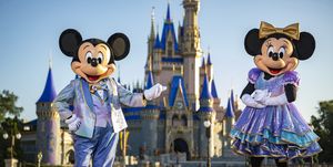 mickey mouse y minnie mouse posan frente al castillo de cenicienta en magic