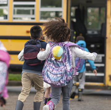 diverse group of happy children getting on school bus