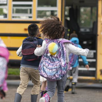 group of kids running toward a school bus