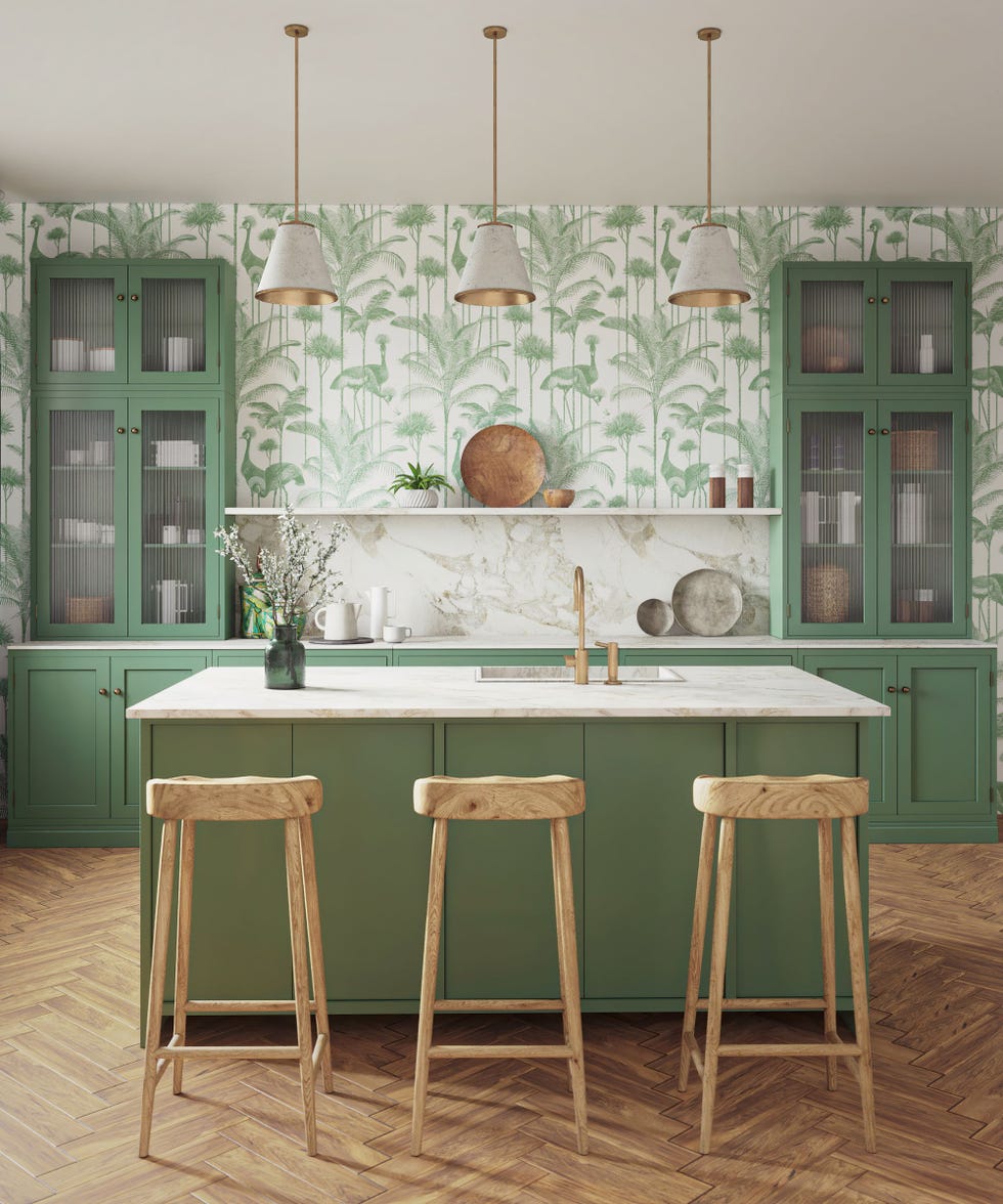 soft green Shaker kitchen with white and green leaf wallpaper, marble countertops and parquet floor