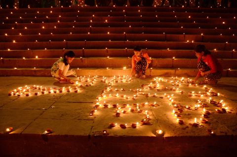 De herfst is in India de tijd van het jaarlijkse Divalifestival een tijd om de duisternis met lichtjes te verdrijven De trappen aan de rivier de Ganges worden door duizenden kleilampjes of diyas verlicht