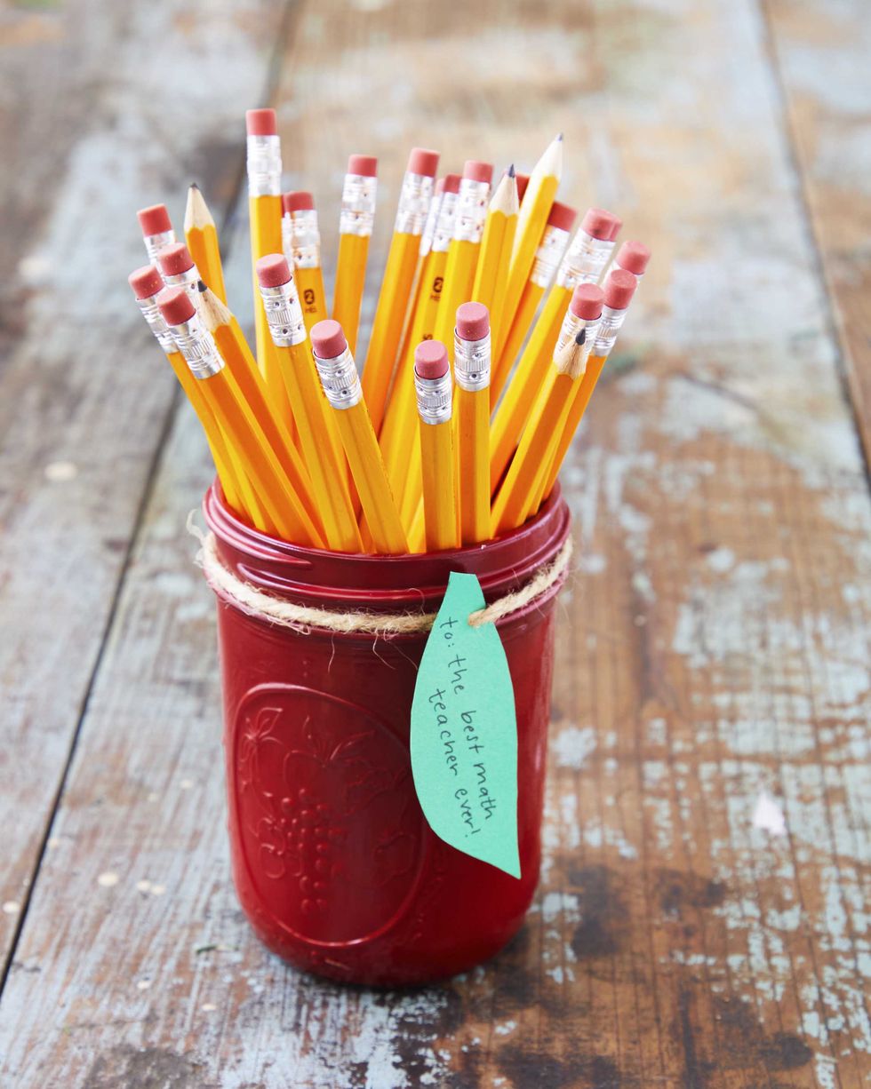 Red painted mason jar with green leaf gift tag and pencil