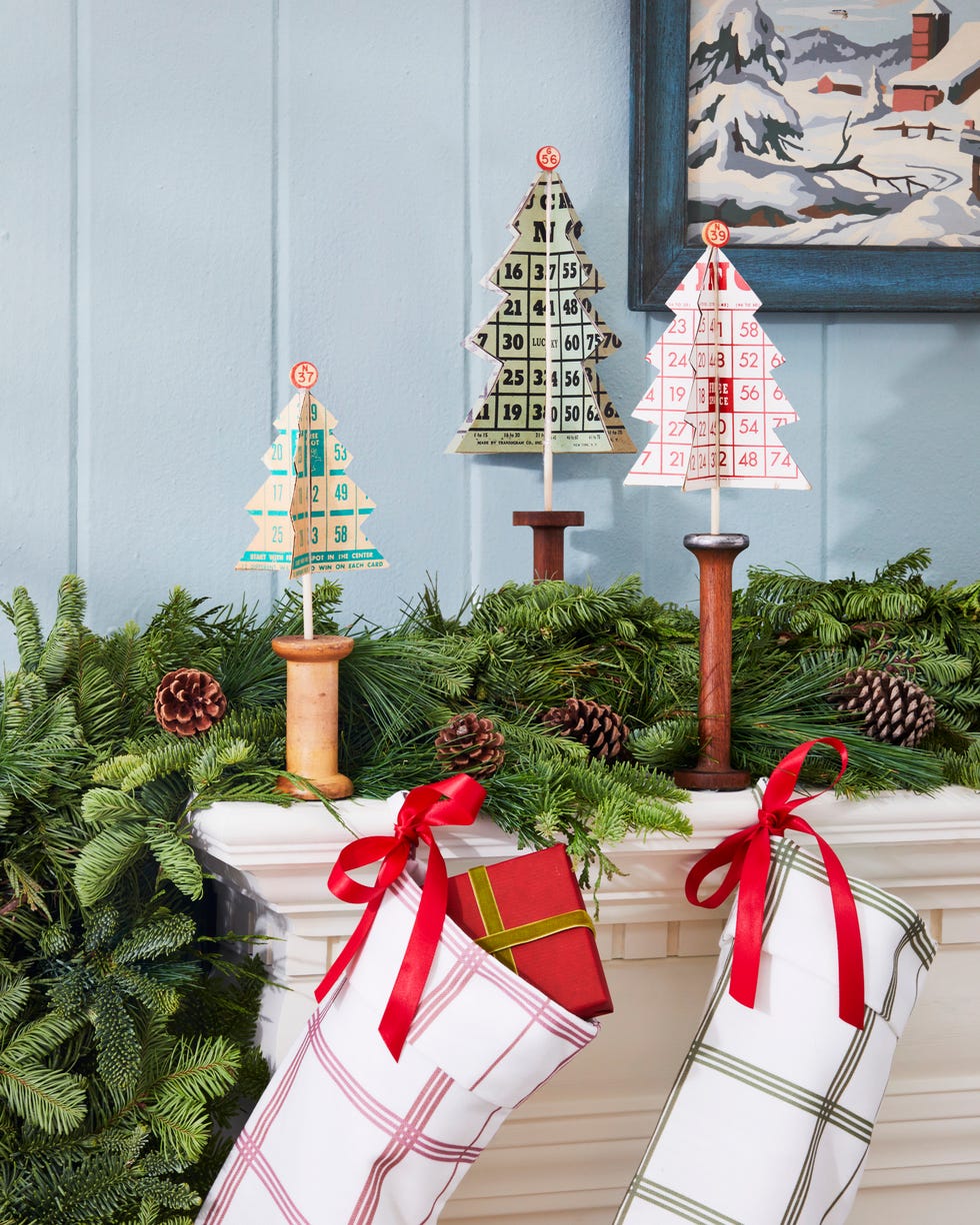 mini tree made from vintage bingo cards set in vintage wooden spools on a mantel