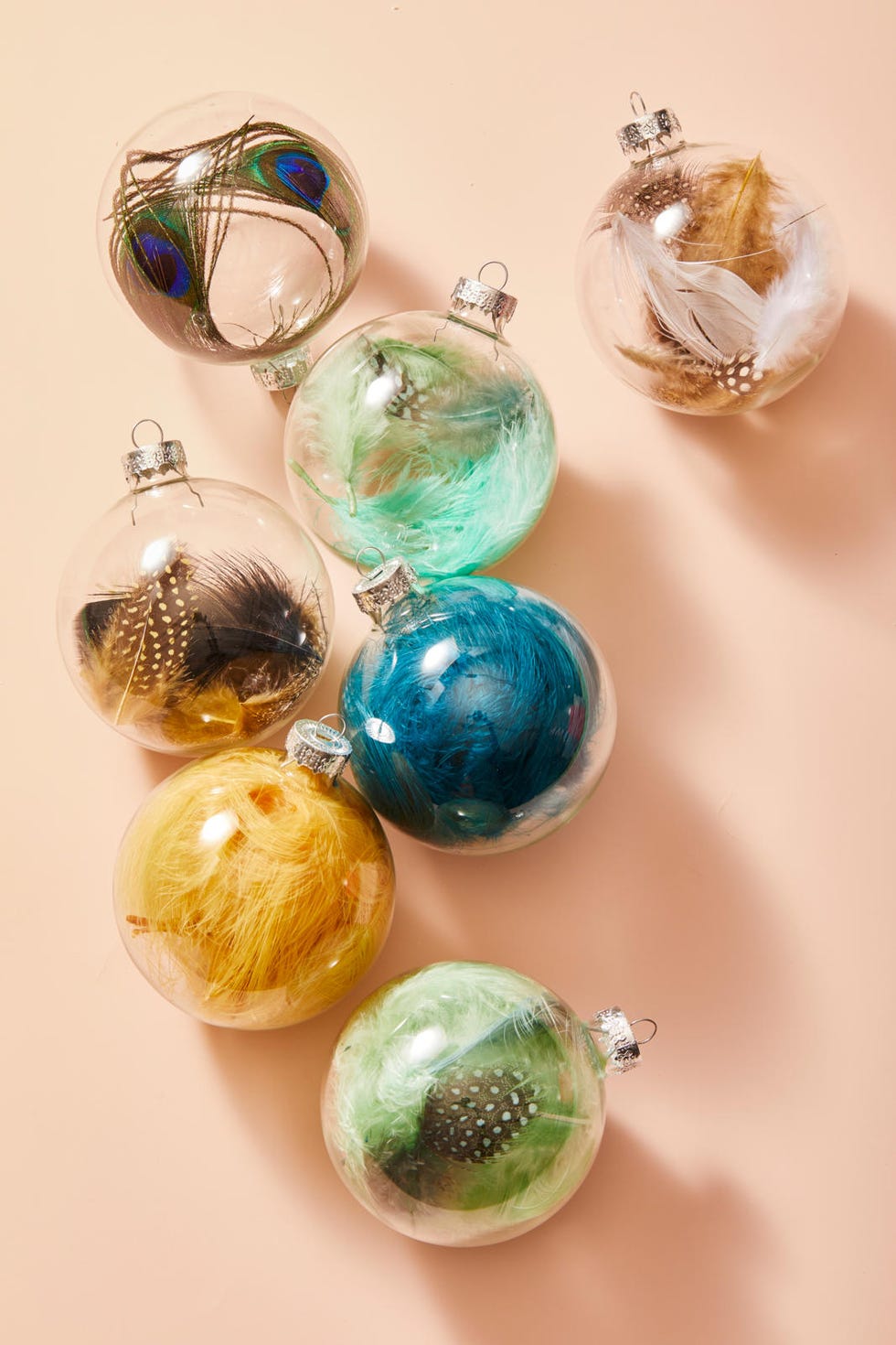 diy christmas gifts, clear glass ornaments with feathers inside