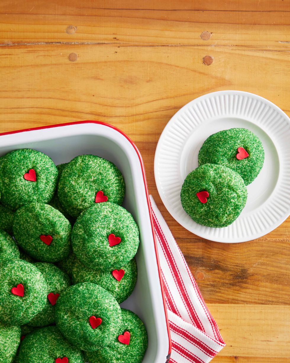 Green sugar-covered Grinch cookies with red candy hearts tucked into them