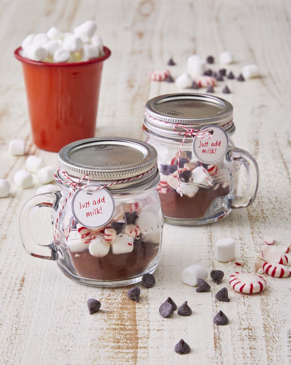 mini mug mason jars filled with hot chocolate mix and topped with chocolate chips mini marshmallows, and broken starligh mints