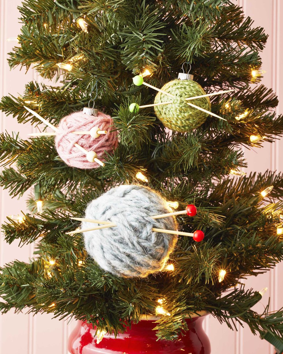 ornaments wrapped with yarn and threaded with cocktail pics meant to look like knitting needles