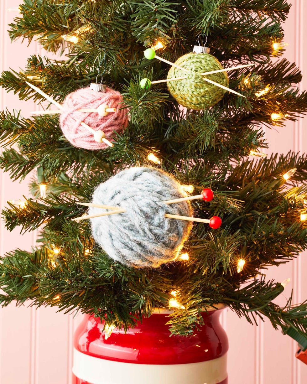 ornaments wrapped with yarn and threaded with cocktail pics meant to look like knitting needles