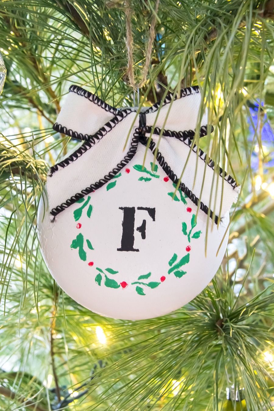 diy christmas gifts, white ornament on the tree with an f monogram and a white ribbon