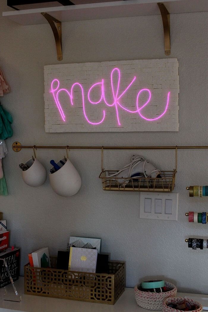 diy christmas gifts, neon sign that reads make and glows pink in the dark above the desk