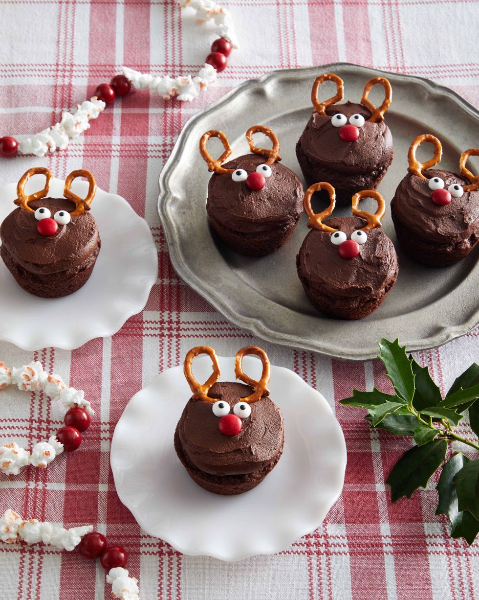 chocolate brownies decorated with frosting candy and mini pretzel antlers so it all looks like a reindeer