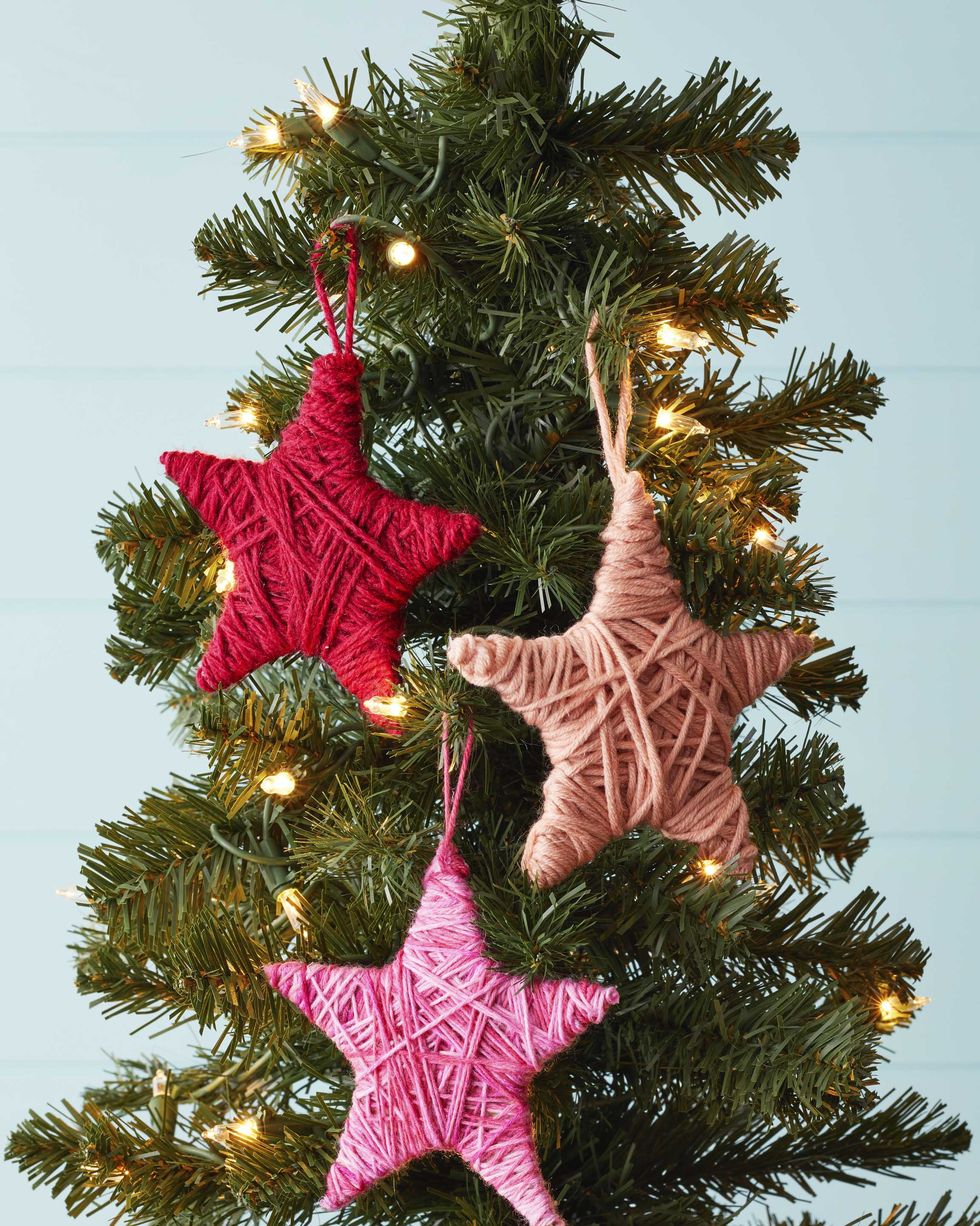 star shaped ornaments covered in colorful yarn hung on a christmas tree