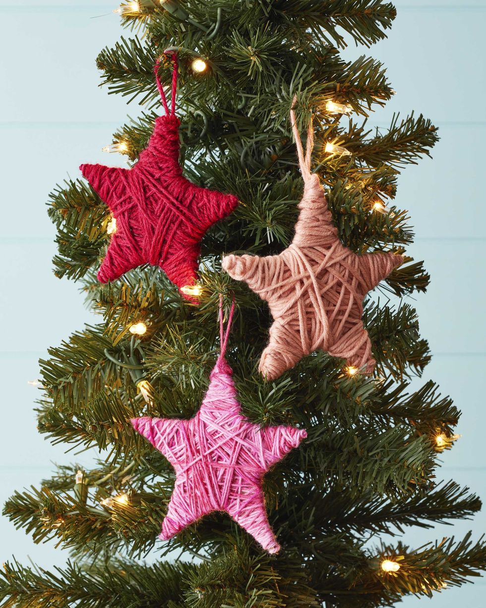 star shaped christmas ornaments wrapped in yarn hung on a tree