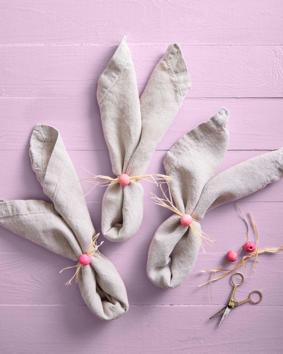 napkins folded into bunny ears with painted pink wooden craft ball noses