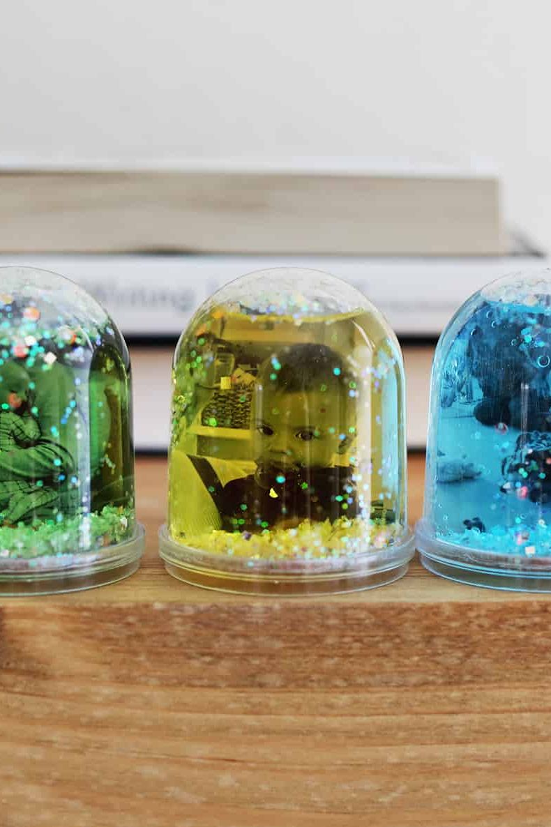 diy christmas gifts, three clear globes with baby photos and glitter inside