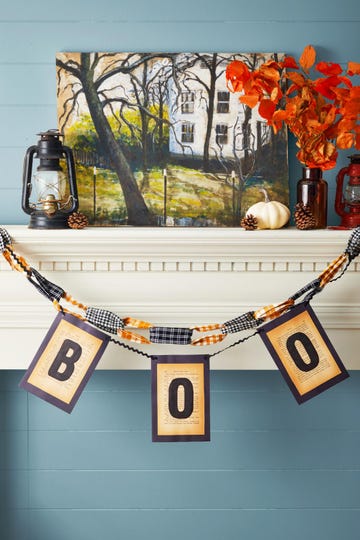 boo garland made from vintage book pages hung on a mantel