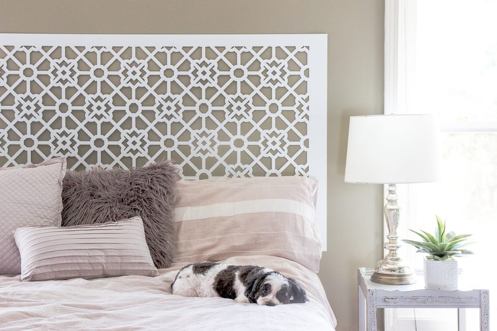 diy headboard in beige bedroom with cutout pattern screen behind a bed