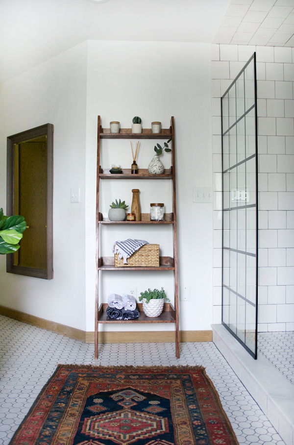 wooden ladder shelf displaying decorative items in a bathroom