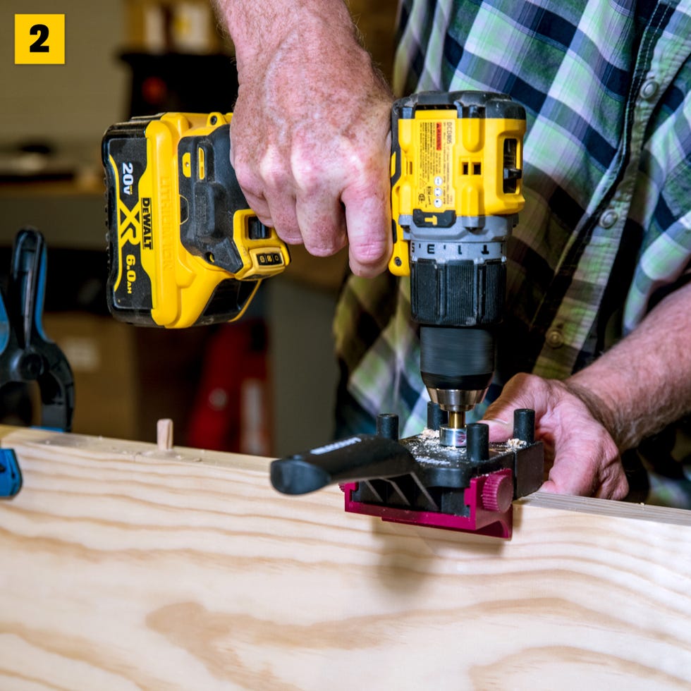 una persona que usa un taladro eléctrico en una superficie de madera con una pieza de trabajo sujetada