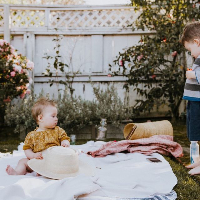 two toddlers on picnic blanket in garden