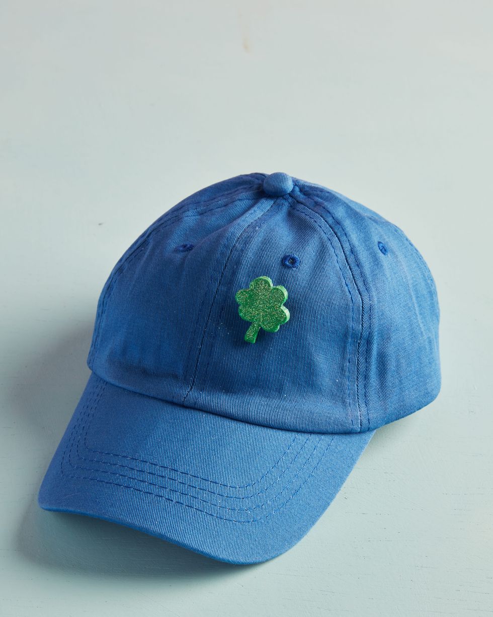 sparkly green st patricks day clover pin on a blue baseball hat