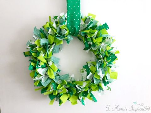 st patricks day wreath crafted from fabric strips of various shades and patterns of green tied onto round wreath form