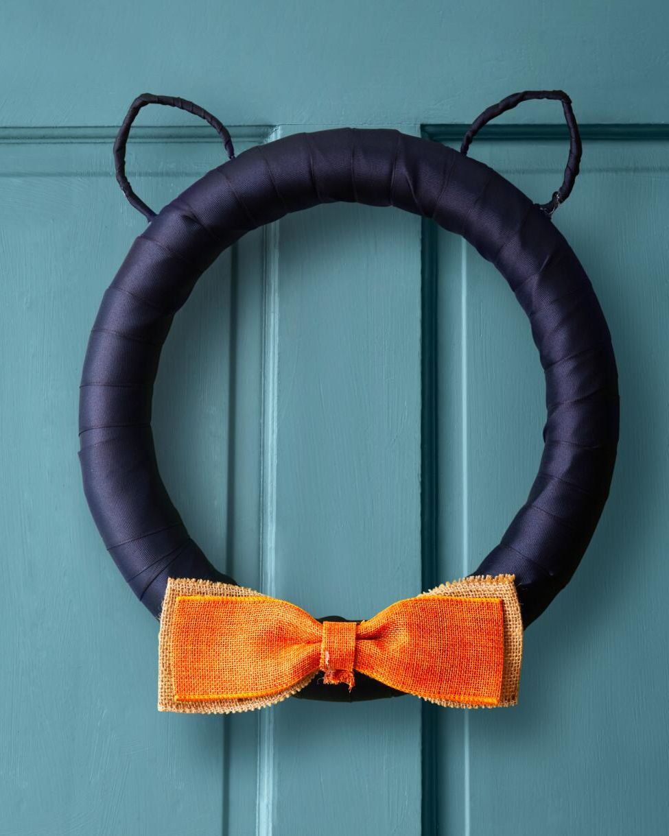 a front door wreath made to look like a cat with an orange bowtie