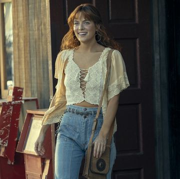riley keough as daisy wears a lace crop top and high rise jeans from daisy jones and the six