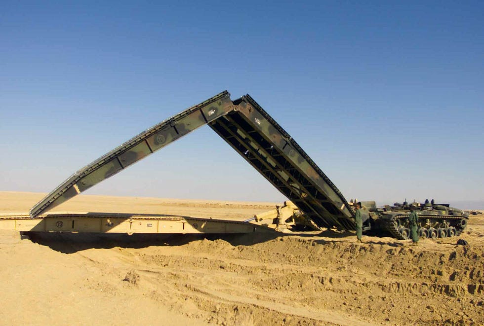 us marine corps usmc marines assigned to headquarter company, 1st tank battalion, deploy two m60a1 armored vehicle landing bridges avlb, over a dry wash at camp coyote, kuwait, during operation enduring freedom