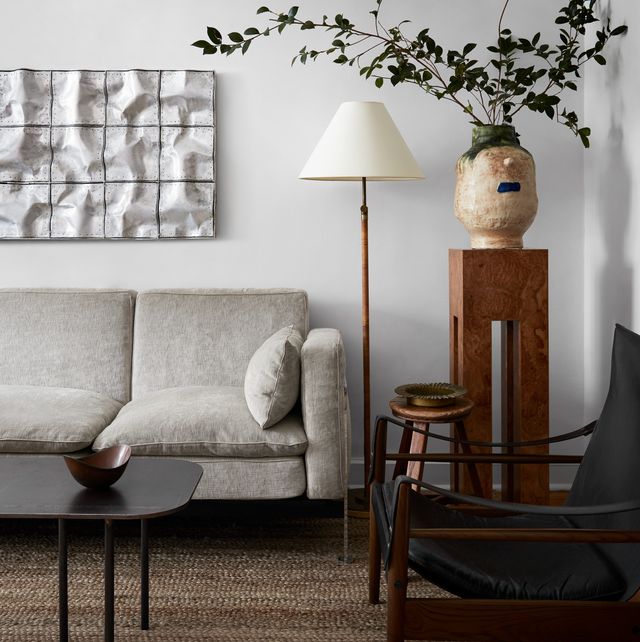 living room, gray sofa, wooden side table, coffee table, black leather arm chair, wall art, white shade lamp