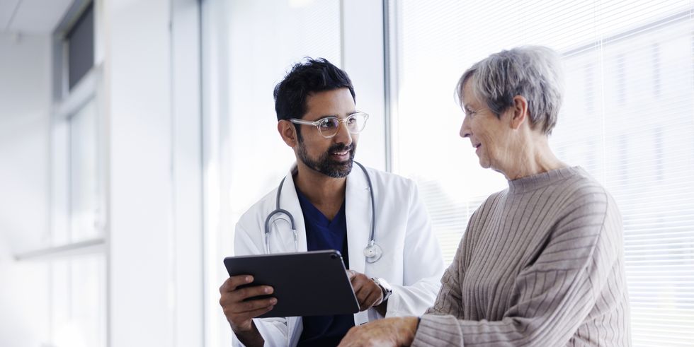 doctor and patient in conversation, looking at digital tablet