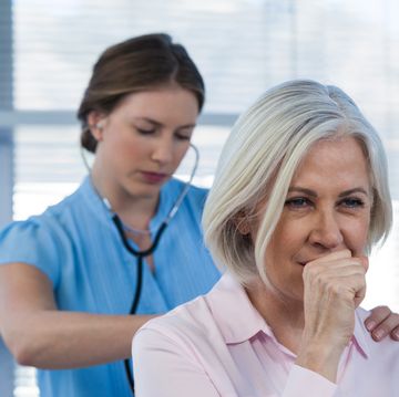 doctor examining coughing patient