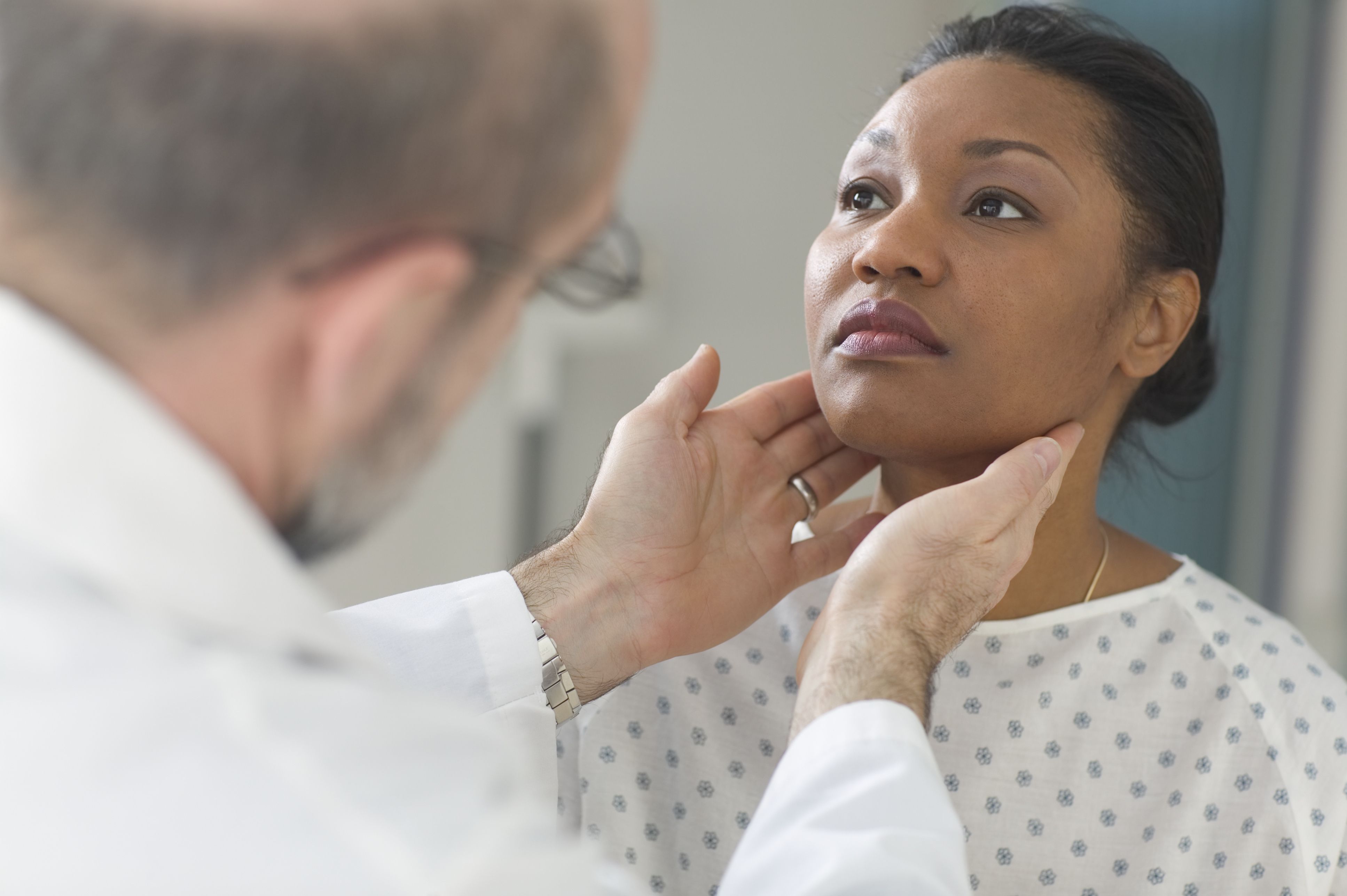 Doctor examining glands of female patient
