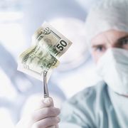 doctor holding a fifty dollar bill with tweezers