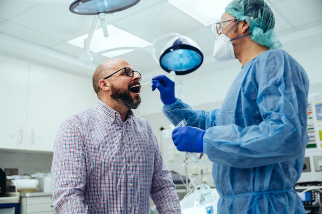 doctor in hospital taking a swab from patient's mouth