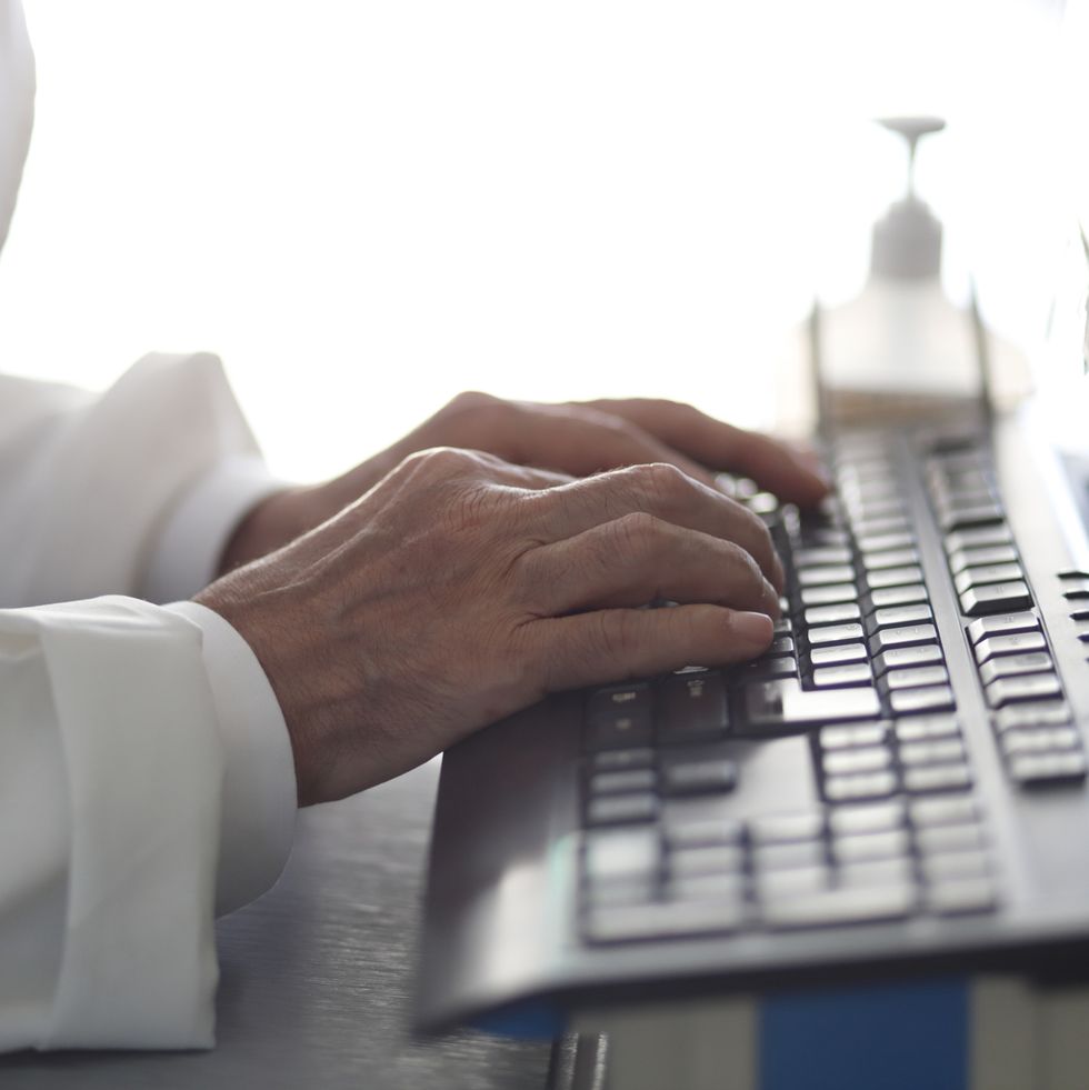 doctor reviewing records on desktop pc