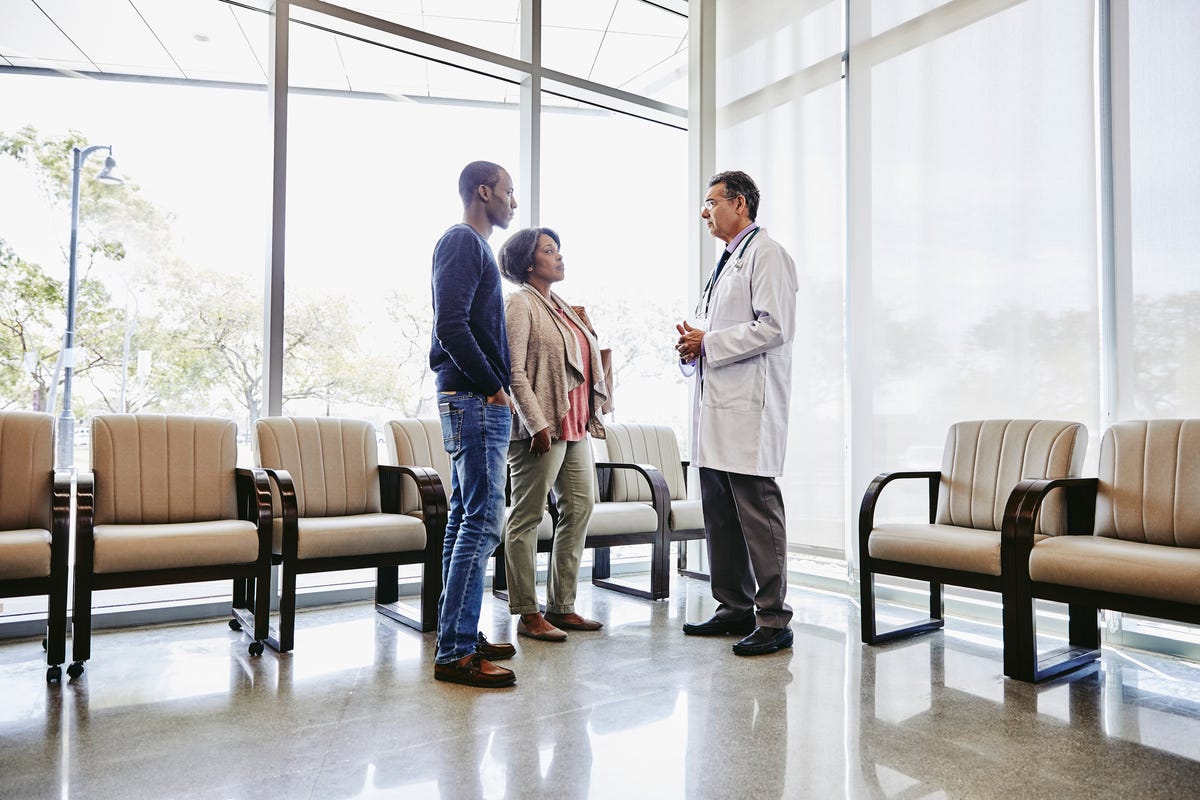 doctor talking to mother and son in hospital waiting room