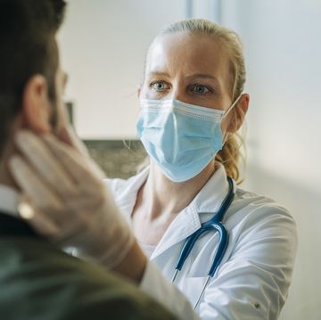 doctor wearing surgical mask examining man
