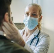 doctor wearing surgical mask examining man